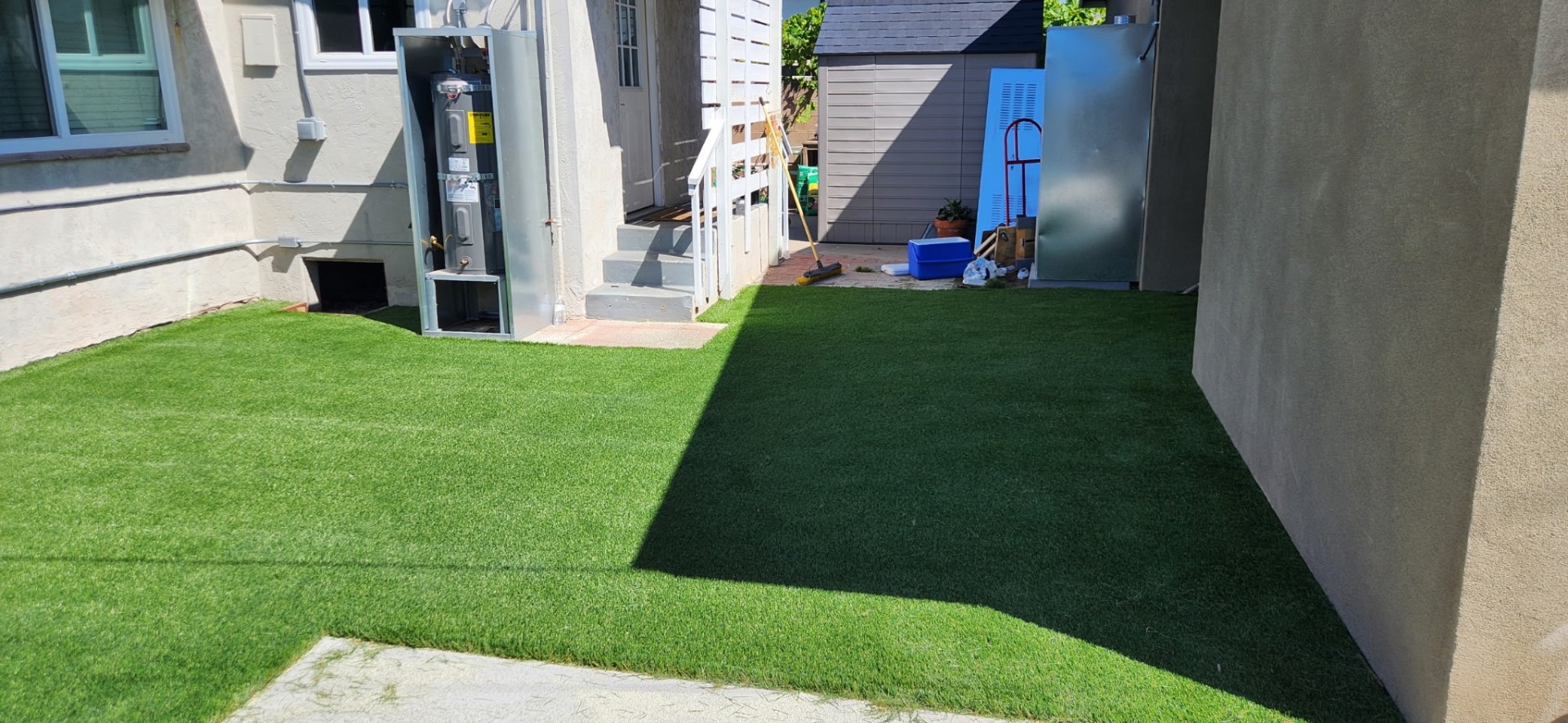 Side yard with freshly installed bright green artificial turf